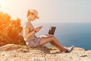 Woman sea laptop. Business woman, freelancer with laptop working over blue sea beach. Happy smiling girl relieves stress from work. Freelance, remote work on vacation, digital nomad, travel concept photo