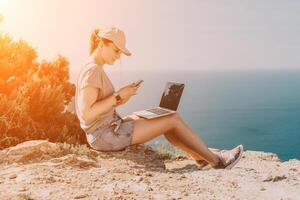 Woman sea laptop. Business woman, freelancer with laptop working over blue sea beach. Happy smiling girl relieves stress from work. Freelance, remote work on vacation, digital nomad, travel concept photo