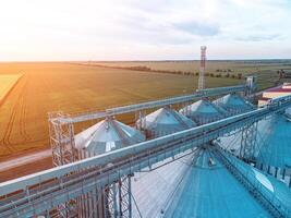 Modern metal silos on agro-processing and manufacturing plant. Aerial view of Granary elevator processing drying cleaning and storage of agricultural products, flour, cereals and grain. Nobody. photo