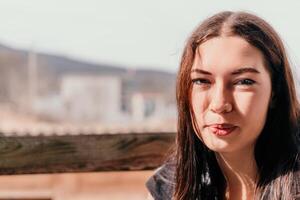 contento joven sonriente mujer con pecas al aire libre retrato. suave soleado colores. al aire libre de cerca retrato de un joven morena mujer y mirando a el cámara, posando en contra otoño naturaleza antecedentes foto