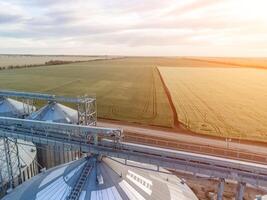 Modern metal silos on agro-processing and manufacturing plant. Aerial view of Granary elevator processing drying cleaning and storage of agricultural products, flour, cereals and grain. Nobody. photo