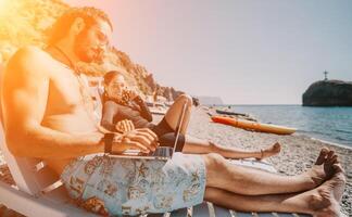 Man woman laptop sea. Working remotely on seashore. Happy successful couple, freelancers working on sea beach, relieves stress from work to restore life balance. Freelance, remote work on vacation photo