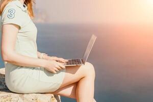 Woman sea laptop. Business woman, freelancer with laptop working over blue sea beach. Happy smiling girl relieves stress from work. Freelance, remote work on vacation, digital nomad, travel concept photo