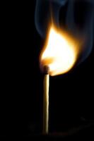 Wooden match burning on a black background photo