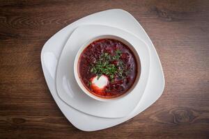 rojo sopa de remolacha sopa con eneldo en blanco bol. foto