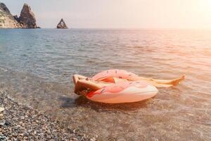 Summer Vacation Woman floats on an inflatable donut mattress, a water toy swim ring. Positive happy woman relaxing and enjoying family summer travel holidays vacation on the sea. Slow motion photo