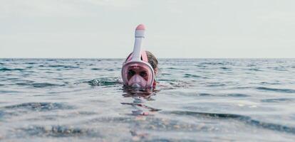 joven contento mujer en blanco bikini y vistiendo rosado máscara obtiene Listo para mar bucear. positivo sonriente mujer relajante y disfrutando agua ocupaciones con familia verano viaje Días festivos vacaciones en mar. foto