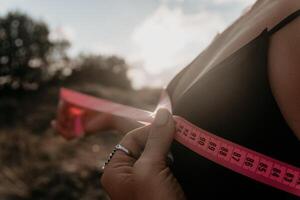 A woman is holding a pink tape measure and is measuring her breasts after morning fitness photo