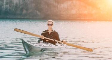 mujer mar kayac. contento sonriente mujer en kayac en océano, remar con de madera remo. calma mar agua y horizonte en antecedentes. activo estilo de vida a mar. verano vacaciones. foto