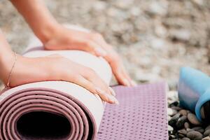 Pilates magic ring and rubber band on yoga mat near sea. Female fitness yoga concept. Healthy lifestyle harmony and meditation. photo