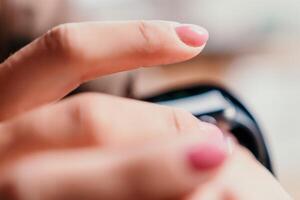 Woman hand using smart watches mobile app with touch screen. New gadget to stay connected to internet. Stylish touchscreen wrist watches with navigation mobile application. Close up. Selective focus photo