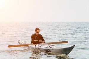 mujer mar kayac. contento sonriente mujer en kayac en océano, remar con de madera remo. calma mar agua y horizonte en antecedentes. activo estilo de vida a mar. verano vacaciones. foto