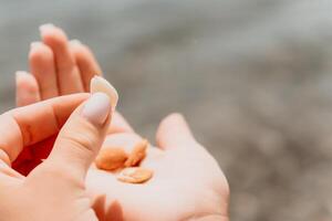 Woman eating milky almond nuts. A young caucasian woman chopping fresh green almond after morning fitness yoga near sea. Only hands are visibly. Healthy vegan food. Slow motion. Close up photo