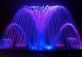 Coloured water fountain at night photo