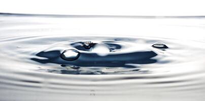 la gota de agua redonda y transparente, cae hacia abajo foto