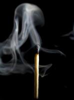 Wooden match burning on a black background photo