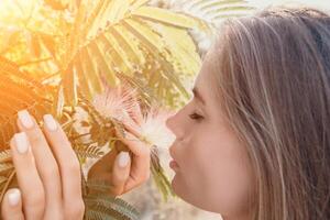 Beauty portrait of happy woman closeup. Young girl smelling Chinese acacia pink blossoming flowers. Portrait of young woman in blooming spring, summer garden. Romantic vibe. Female and nature photo