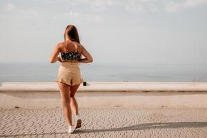 mujer verano bailar. silueta de un contento mujer quien bailes, giros y levanta su manos a el cielo. un juguetón joven mujer disfruta su contento momento bailando en el rayos de el dorado Dom. foto