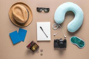 Packed suitcase of vacation items on wooden table, top view photo