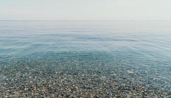 A calm body of water with a few rocks scattered throughout photo