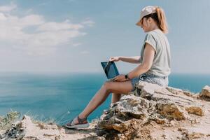 Woman sea laptop. Business woman, freelancer with laptop working over blue sea beach. Happy smiling girl relieves stress from work. Freelance, remote work on vacation, digital nomad, travel concept photo