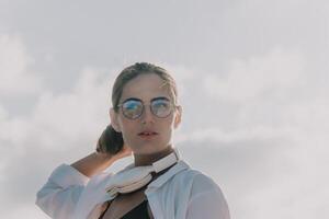 Woman park laptop. Young woman in glasses, freelancer with laptop working in summer park on sunset. Happy smiling girl relieves stress from work. Freelance, remote work, digital nomad, travel concept photo