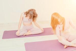 bien mirando medio Envejecido deportivo mujer, aptitud instructor en rosado ropa de deporte haciendo extensión y pilates en yoga estera en el estudio con espejo. hembra aptitud yoga. sano estilo de vida y armonía. foto