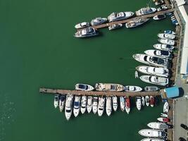 Aerial panoramic view of Balaklava landscape with boats and sea in marina bay. Crimea Sevastopol tourist attraction. Drone top view shot of port for luxury yachts, boats and sailboats. photo