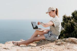 Woman sea laptop. Business woman, freelancer with laptop working over blue sea beach. Happy smiling girl relieves stress from work. Freelance, remote work on vacation, digital nomad, travel concept photo