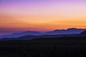 view of a valley in a beautiful early night with fog between hills photo