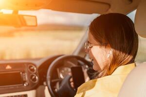Happy woman talking on the phone while sitting in the car on nature Relaxed call, professional conversation, female executive in automobile. business woman talking on call on phone. photo