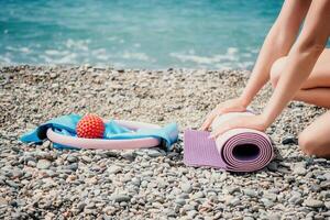 Pilates magic ring and rubber band on yoga mat near sea. Female fitness yoga concept. Healthy lifestyle harmony and meditation. photo