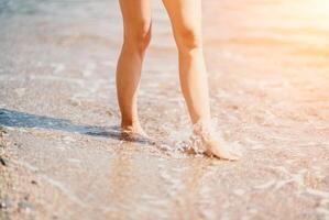 un mujer camina a lo largo el playa, piernas de cerca. descalzo mujer sta foto