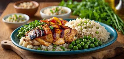 Grilled chicken, with rice and green peas served on plate, wooden rustic table background. Close-up view, grilled chicken thigh with grill marks, surrounded by rice and green peas . photo