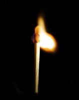 Wooden match burning on a black background photo