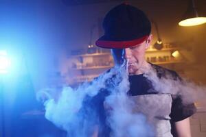 The man smoke an electronic cigarette at the vape shop photo
