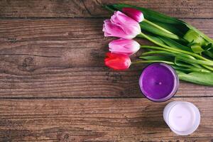 rosado tulipán flores y dos cendel en rústico mesa para marzo 8, internacional De las mujeres día, cumpleaños, san valentin día o madres día - parte superior ver foto