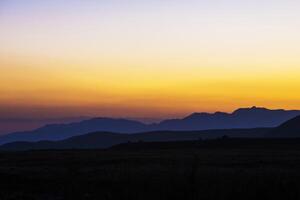 view of a valley in a beautiful early night with fog between hills photo