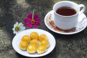 cheese cake with tea and flowers beside photo