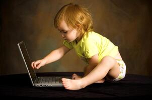 pequeño niña trabajos con el computadora foto