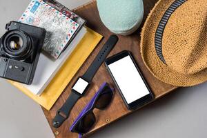 Packed suitcase of vacation items on wooden background. photo