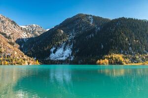 Autumn photo after snowfall, mountain lake Issyk in Almaty region, Kazakhstan. October.