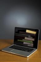 Stack of book and laptop photo