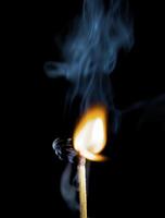 Wooden match burning on a black background photo