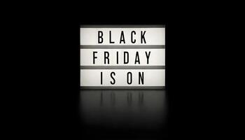 A lightbox with the words BLACK FRIDAY IS ON illuminated on a dark background photo