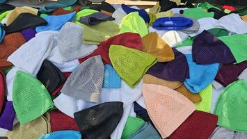 many different colored prayer hats or caps are piled up on top of each other photo