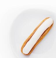 Dessert Eclair with whipped cream and sugar icing photo