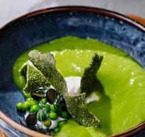 peas, broccoli, spinach cream soup in a bowl photo