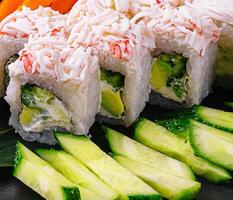 Sushi rollos con cangrejo palos y pepinos foto