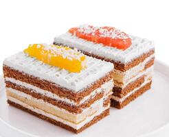 two slices of multilayer cocoa sponge cake with coconut flakes photo